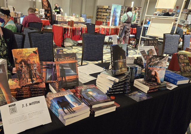 Photo shows a table of books for sale including piles of Endurance, Tenacity, and Resolution by Elaine Burnes